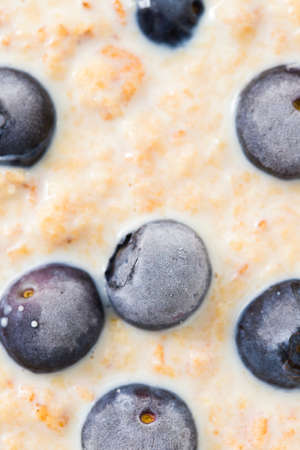 healthy wheat flakes with milk and blueberries in white bowlの写真素材