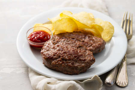 fried ground meat with tomato sauce and potato chips on dish