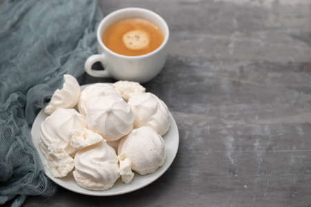cup of coffee with meringues on white dishの写真素材