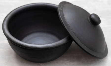 small beautiful black ceramic pot on ceramic backgroundの写真素材