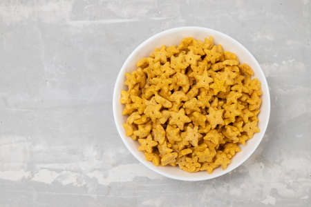 sweet yellow corn flakes in white small bowl on ceramicの写真素材