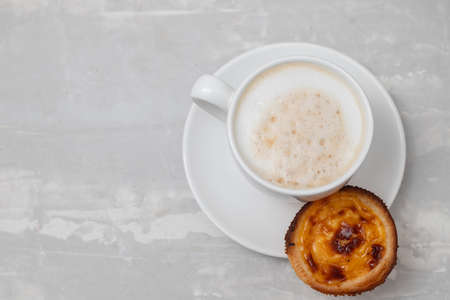 typical portuguese dessert pastel de nata with cup of coffeeの写真素材
