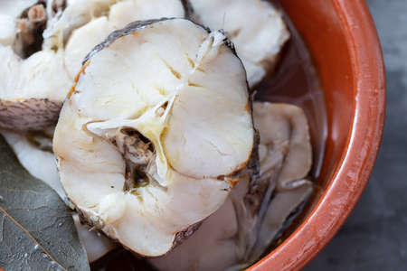 boiled fresh fish in brown ceramic pot on ceramicの写真素材
