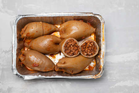 stuffed squids in plastic box take away on ceramic
