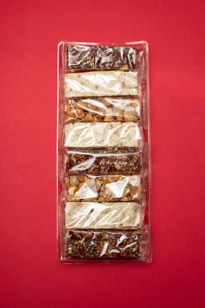 typical spanish sweets with nuts in small plastic bag on red