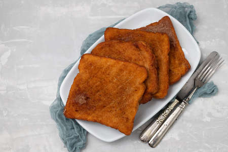 typical portuguese Christmas dessert fried bread with cinnamon on white dishの写真素材
