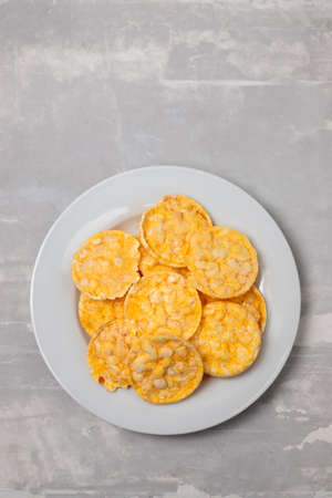 small puffed corn cakes on small white plate on ceramicの写真素材
