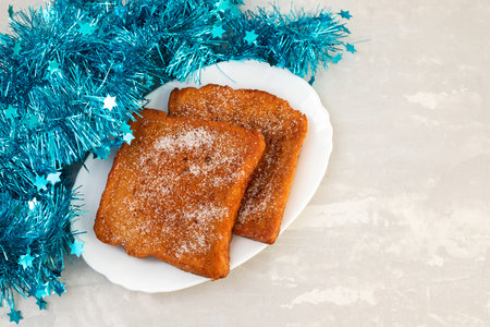 typical portuguese Christmas dessert fried bread with cinnamon on white dishの写真素材