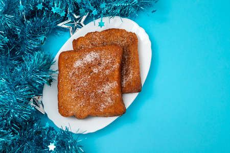 typical portuguese Christmas dessert fried bread with cinnamon on white dishの写真素材