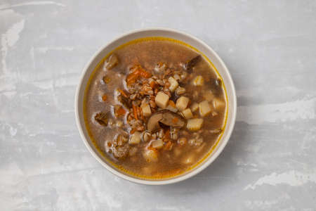 fresh mushrooms soup in small brown bowl on ceramicの写真素材