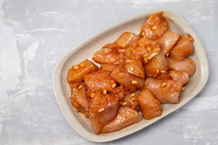 raw meat with marinate on brown dish on gray ceramicの写真素材