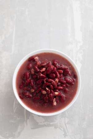boiled red beans in small white bowl on gray ceramicの写真素材
