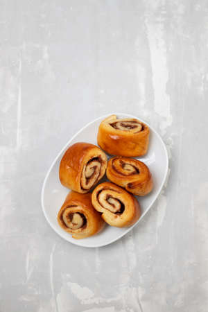 small cinnamon buns on a white dish on ceramicの写真素材