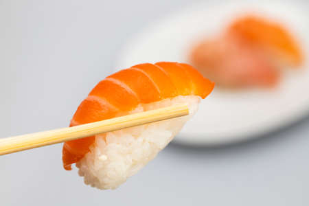 Assorted sushi on small white dish and one with stick macroの写真素材