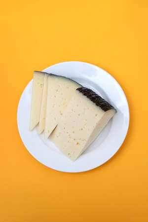 cheese slices on white small plate on yellow paperの写真素材