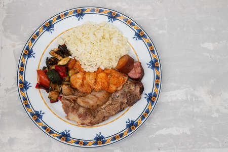 grilled meat with vegetables and boiled rice on the plateの写真素材