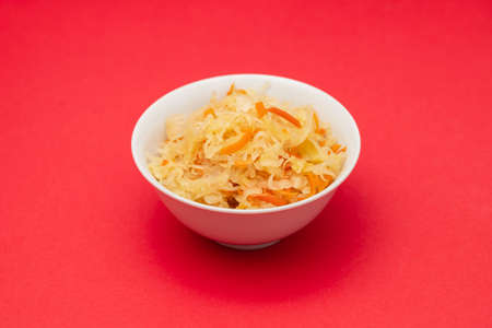 salted cabbage with carrot in white bowl on red paperの写真素材