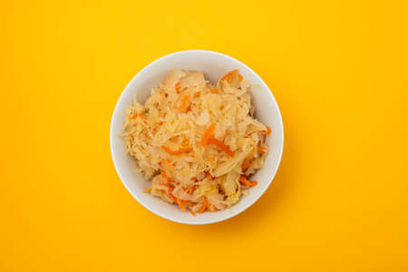 salted cabbage with carrot in white bowl on yellow paperの写真素材
