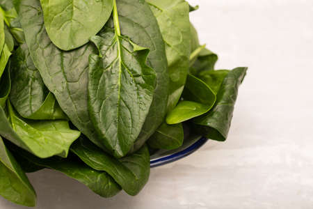 fresh green spinach on dish on gray ceramicの写真素材
