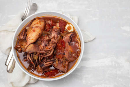 fresh tasty squid stew in white bowl on ceramicの写真素材
