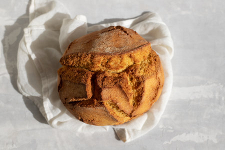 typical portuguese corn bread with napkin on gray ceramic