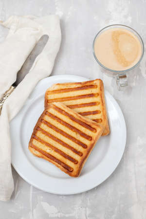 fresh breakfast toasts on white plate on gray ceramicの写真素材