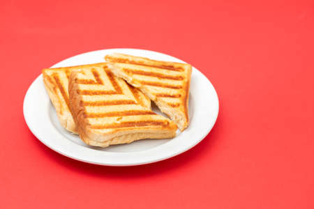fresh breakfast toasts on white plate on yellowの写真素材