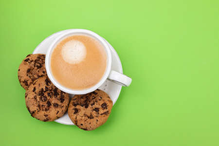 a cup of coffee with cookies chocolate drops on greenの写真素材