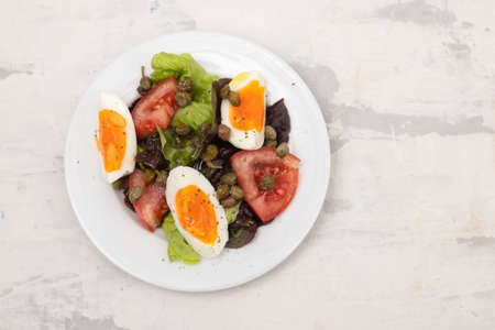 fresh vegetable salad with boiled egg on white small dishの写真素材