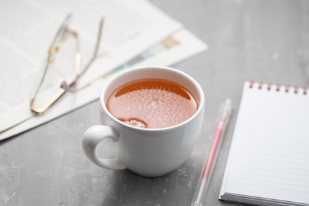 Newspapers and white tea cup, with reading glasses.の写真素材