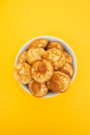 Heap of mini cereal pancakes in bowl on bright background.の写真素材