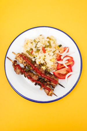 Meat and Cooked white rice mixed with colorful vegetables onion, green beans, tomato in white bowlの写真素材