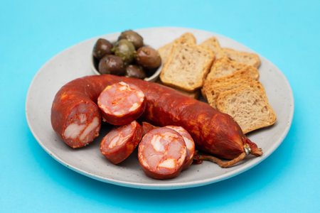 toasts with chorizo and olives on small dishの写真素材
