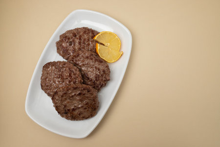 fried cutlet for burger with fresh lemon. In a white plateの写真素材