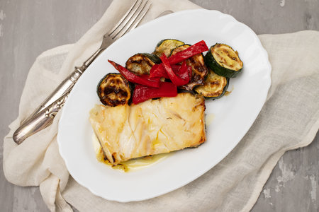 Fish dish - fried cod fish with grilled vegetables in white plate