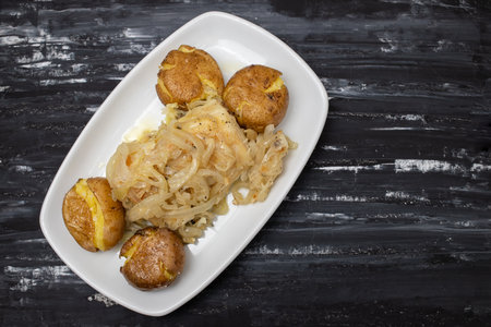 Tasty pieces of baked potatoes and salt and oil on white plateの写真素材