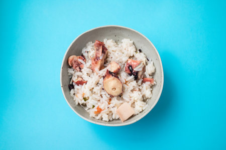 Boiled rice with octopus and spices in white bowlの写真素材