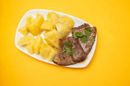 Fried Liver with boiled potato on plateの写真素材