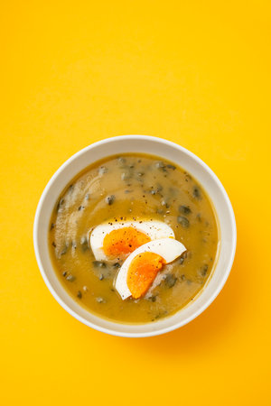 vegetable cream soup with egg in white bowlの写真素材