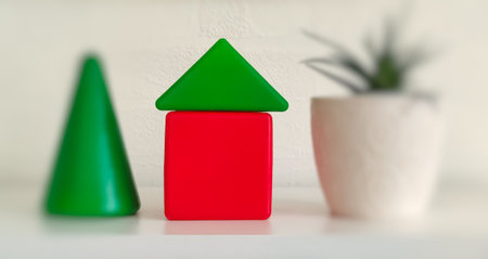 Red and green house in a pot on a white wall background.の写真素材