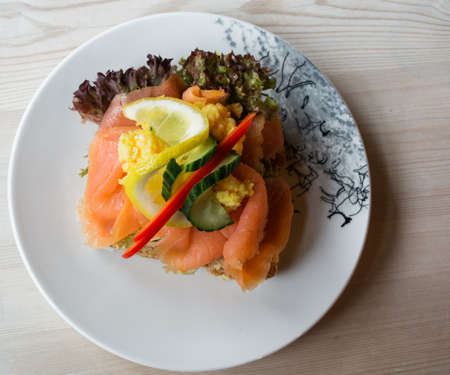 Sandwich with smoked salmon and fresh vegetables, in natural light. Concept for healthy nutrition.の写真素材