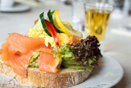 Sandwich with smoked salmon and fresh vegetables, in natural light. Concept for healthy nutrition.の写真素材