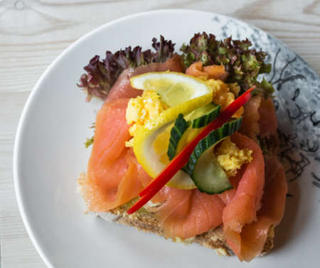 Sandwich with smoked salmon and fresh vegetables, in natural light. Concept for healthy nutrition.の写真素材
