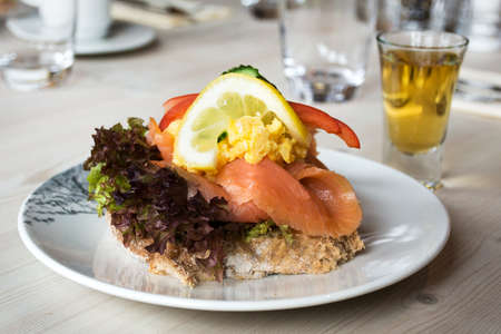 Sandwich with smoked salmon and fresh vegetables, in natural light. Concept for healthy nutrition.の写真素材