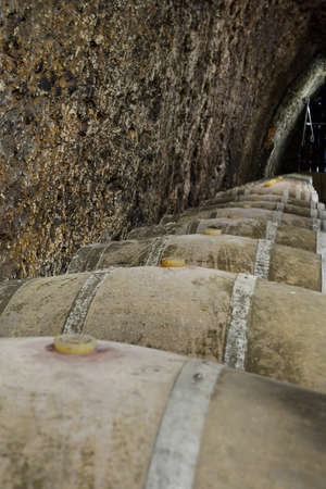 Large, oak barrels of wine in an old cellar, wine production. Close-upの写真素材