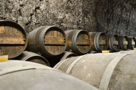 Large, oak barrels of wine in an old cellar, wine production. Close-upの写真素材