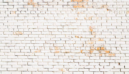 White old scuffed brick wall with cracks backgroundの写真素材