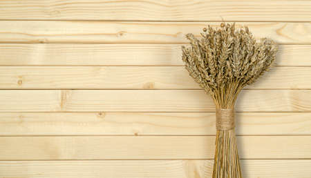 Wheat bouquet on wooden background top view