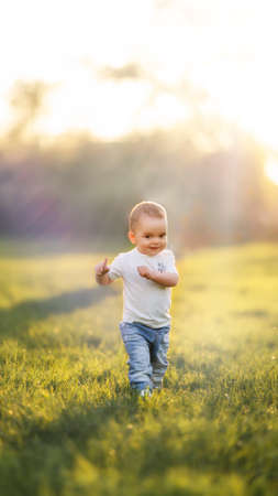 Little kid is walking funny on the grassの写真素材