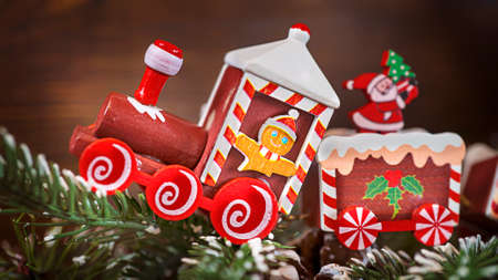 Christmas toy train close-up on a brown wooden background. Christmas card, congratulation, holiday package.の写真素材